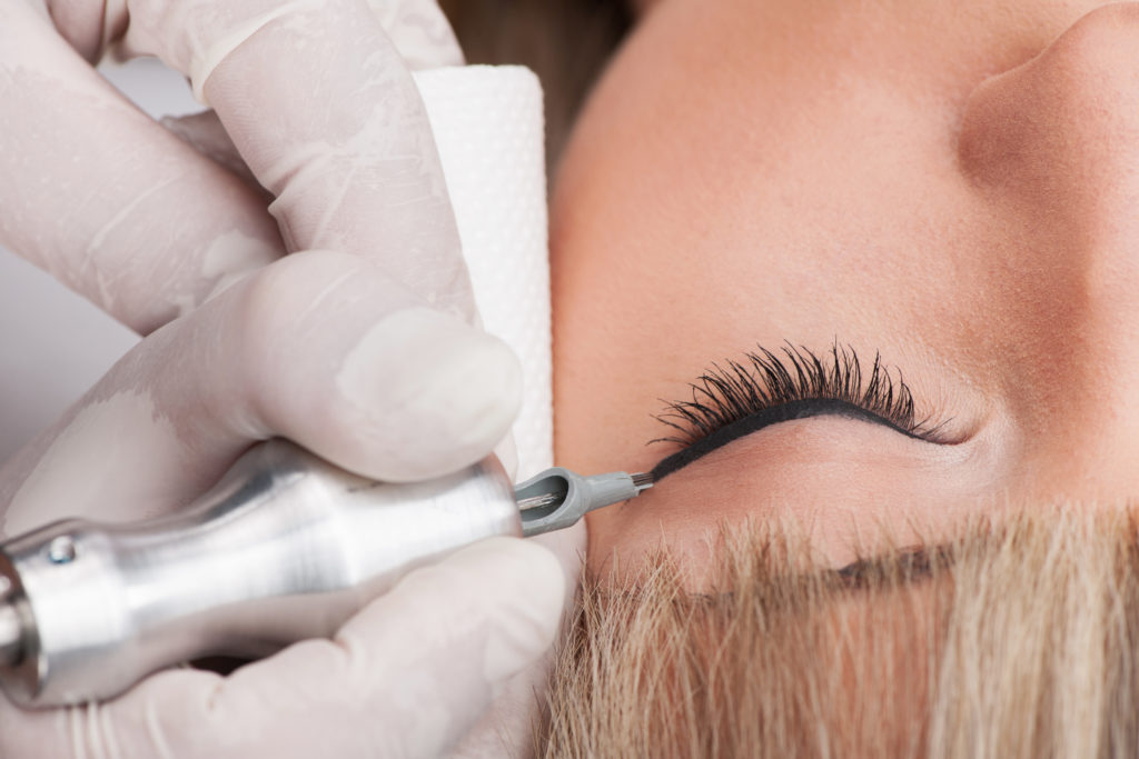 professional tattooist making permanent make-up. Henna pudrowa, makijaż permanentny